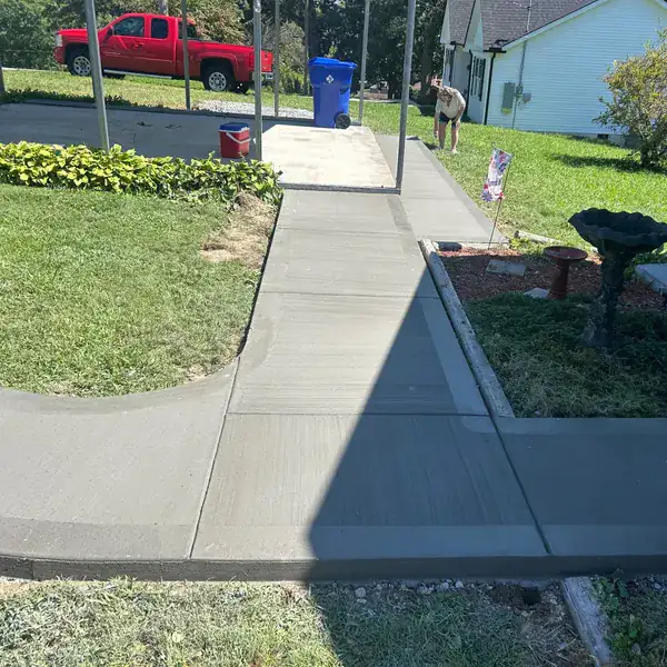 Concrete sidewalk and driveway apron joined at the street
