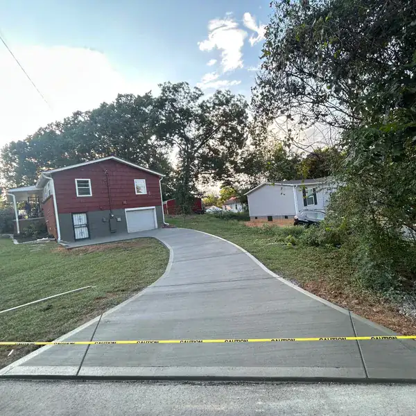New broom-finish driveway running down to the street on a sloped lot