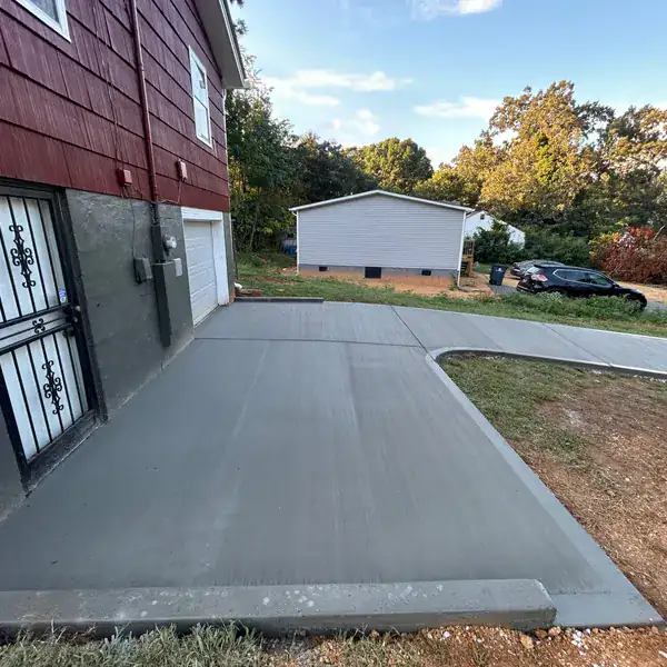Concrete pad poured against a red barn outbuilding in Knoxville, TN