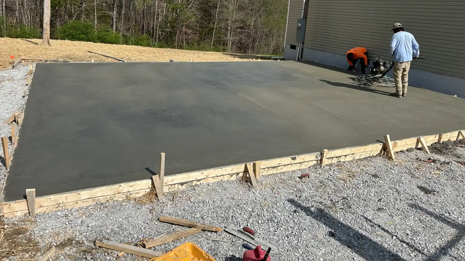 A ride-behind power trowel finishing a fresh concrete slab